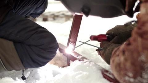 Spot welding of metal structures in winter. Two men are welding a metal frame in Stock Footage 125035503
