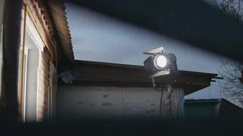 A spotlight for filming shines through the window of the room from the street. Video stock 195334074