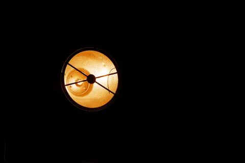 Spotlight illuminates a dark space with a warm orange glow Stock Photos