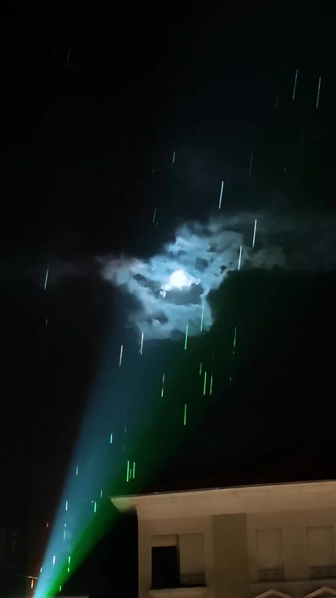 Spotlight illuminating rain drops with full moon in dark night sky Stock Footage 336130622