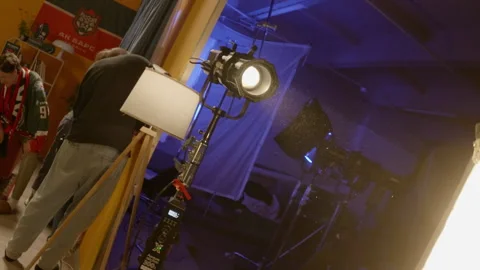 Spotlight stands on set while staff adjusts decorations 動画素材 308930553