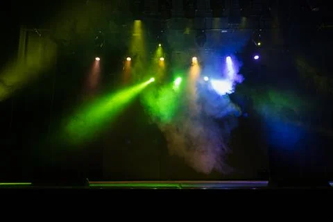 Spotlights in the concert hall. Stage light with colored spotlights and smoke. Stock Photos