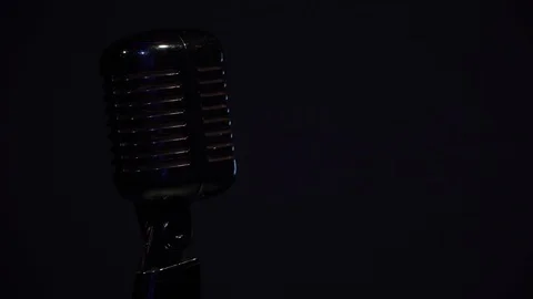 Spotlights shine dull on alone chrome mic on the black background close up. Stock Footage 118528201