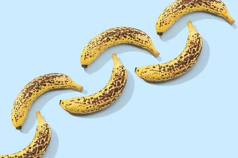 Spotted Banana pattern on blue background. Art food. Copy space Stock Photos