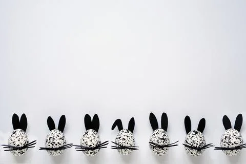 Spotted decorative Easter black and white eggs decorated as bunnies on the white Stock Photos