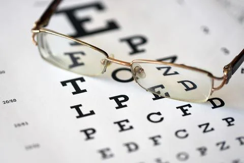 Spotted eyeglasses on eyesight test chart isolated on white. eye examinatio.. 스톡 사진
