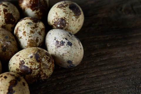 Spotted quail eggs arranged on the background of old wooden boards, with copy Stock Photos