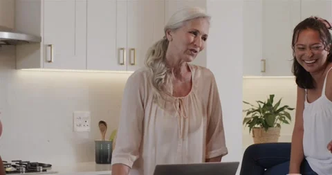 Spotting laptop tutorial, diverse female friends assembling wreath on kitchen Vídeos de archivo 316663999