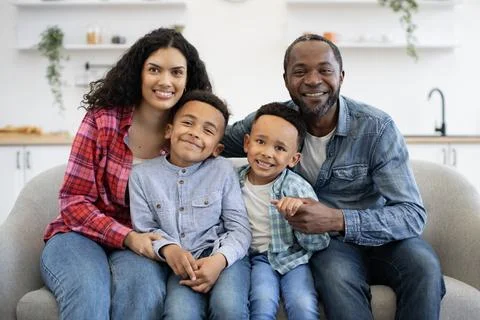 Spouses cuddling kids while making family portrait at home Stock Photos