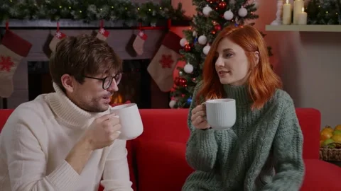 The spouses drinking tea and talking over a Christmas decorated livingroom. Stock Footage 314781823