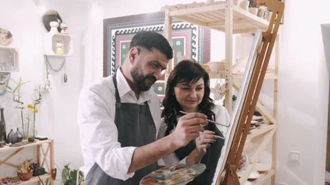 Spouses of middle age are drawing a picture together in art workshop Stock Footage 151092774