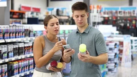 Spouses scans product QR code with phone on color aerosol in paint and vanish Vídeo Stock 256033361