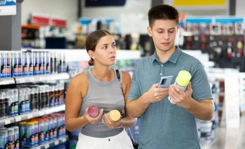 Spouses scans product QR code with phone on color aerosol in paint and vanish Stock Photos