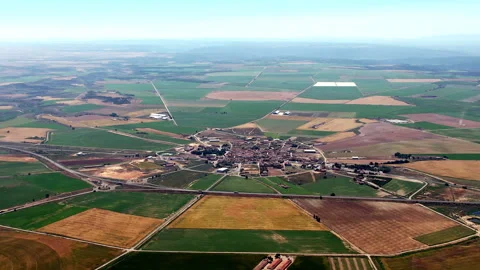 Sprawling green fields radiate from a central town in Spain. Stock Footage 257337412