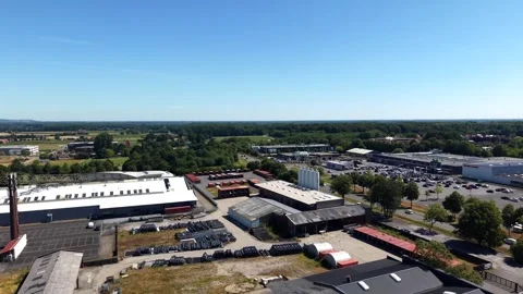 Sprawling industrial complex with flat gray rooftops and tall brick chimney Stock Footage 341672162