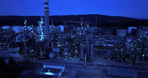 A sprawling industrial refinery complex seen at nighttime emitting a Stock Footage 289942193
