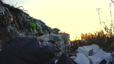 A sprawling mountain of plastic and other waste material rises against the .. Stock Footage 321918199