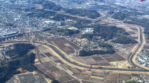 A sprawling town with patchwork fields under a clear sky, day, aerial view Video stock 268398976