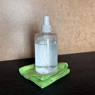 Spray bottle with cleaning solution on cloth 库存照片
