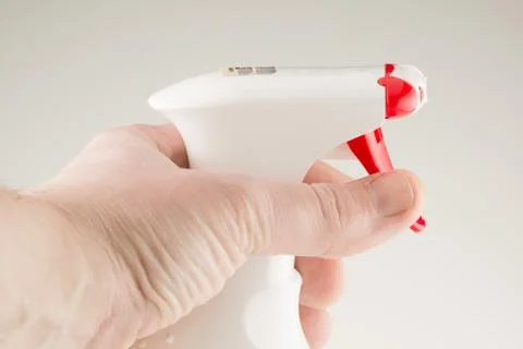 Spray bottle in hand Stock Photos