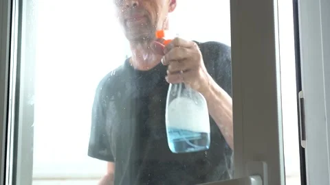 Spray detergent onto window glass. Stock Footage 153258200