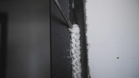 Spray gun fills up a gap between the wall and a door with construction sealant. Stock Footage 237335789