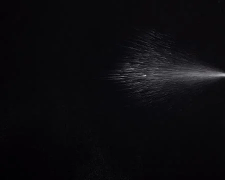 A spray of liquid in a black background. Stock Photos