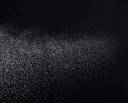 A spray of liquid in a black background. Stock Photos