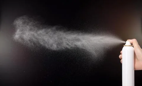 A spray of liquid in a black background. Stock Photos