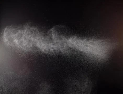 A spray of liquid in a black background. Stock Photos
