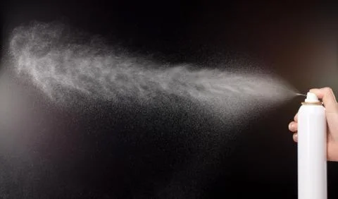 A spray of liquid in a black background. Stock Photos