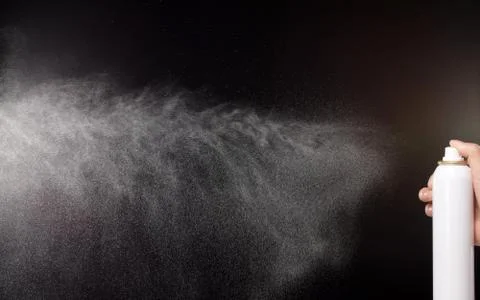 A spray of liquid in a black background. Stock Photos