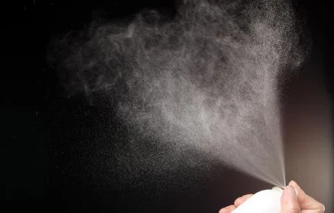 A spray of liquid in a black background. Stock Photos