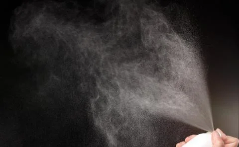 A spray of liquid in a black background. Stock Photos