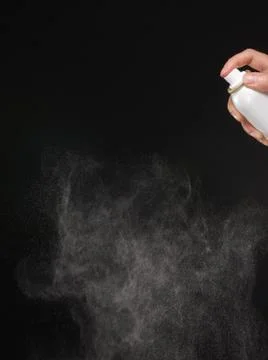 A spray of liquid in a black background. Stock Photos