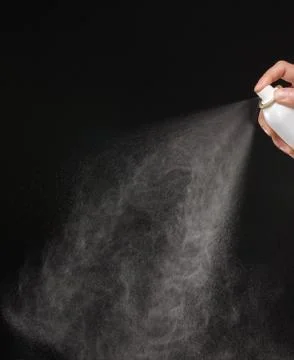 A spray of liquid in a black background. Stock Photos