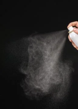A spray of liquid in a black background. Stock Photos