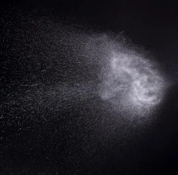 A spray of liquid in a black background. Stock Photos
