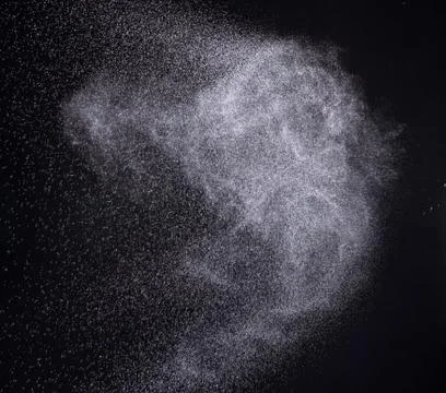 A spray of liquid in a black background. Stock Photos