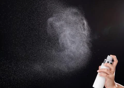 A spray of liquid in a black background. Stock Photos