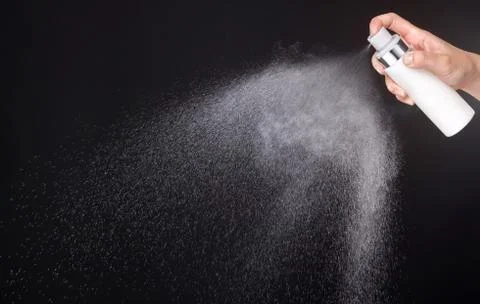 A spray of liquid in a black background. Stock Photos