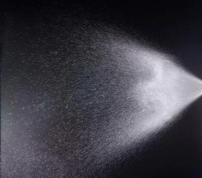 A spray of liquid in a black background. Foto stock