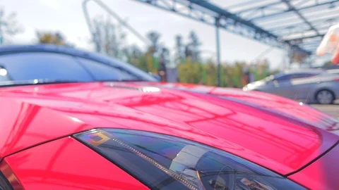 Spray liquid wax on a red convertible and rub with a soft towel to polish Stock Footage 126404738