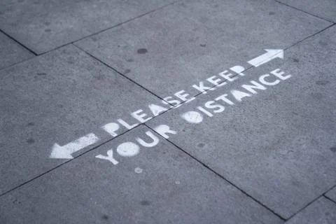 A spray painted please keep your distance pavement sign in London Stock Photos