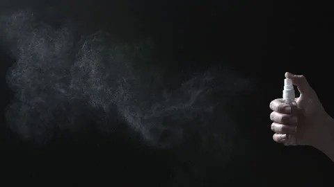 The spray puffs out a stream of liquid. Antiseptic drops on a black background.  Stock Footage 145790952