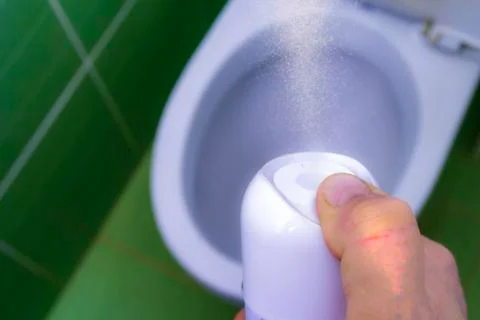 A spray of refreshing liquid comes out of the air freshener can Stock Photos
