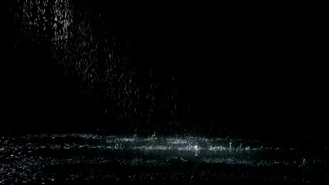 Spray spatters rain fall against on the water surface which glow. Black 스톡 동영상 137558978