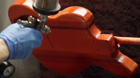 Spray staining a guitar body Stock Footage 147748885