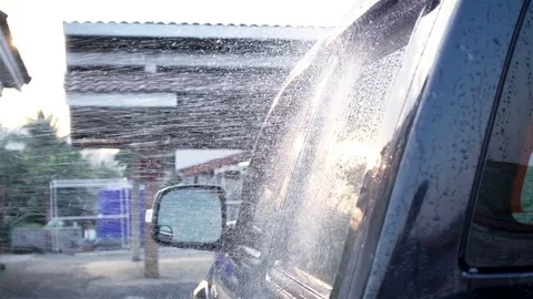 Spray water on car for wash a car with sunbeam, slow motion shot Stock Footage