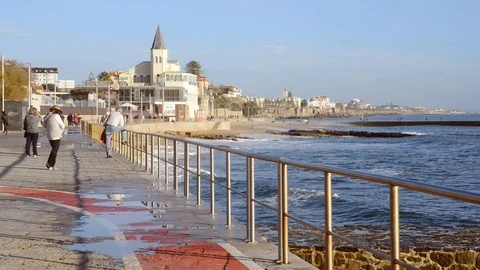 Spray from waves splashing on boardwalk leading to Tamariz beach, Estoril, PT Stock Footage 99536128